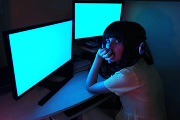 Chica joven adicta a los ordenadores metida en su habitación de noche 