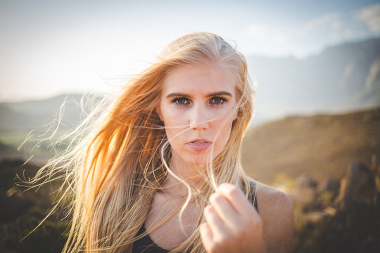 Portrait of a beautiful blond female model in a natural setting with stunning back light