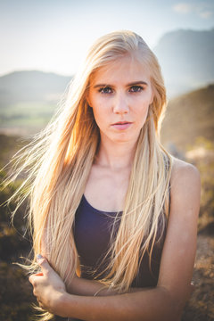 Portrait of a beautiful blond female model in a natural setting with stunning back light