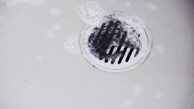 Hair clump in bath drain while taking a shower.