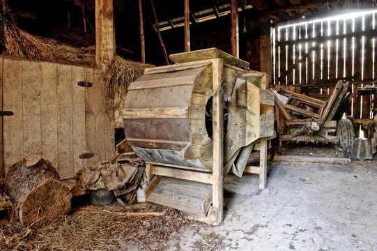 Old wooden threshing machine standing in an old barn