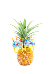 yellow fancy glasses on fresh pineapple, white background, summer birthday concept