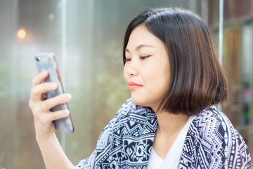 Beautiful young hipster asian women using application to send message on cellphone