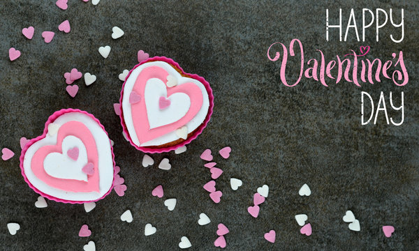HAPPY VALENTINE’S DAY card with cupcakes decorated with hearts arranged on stone background
