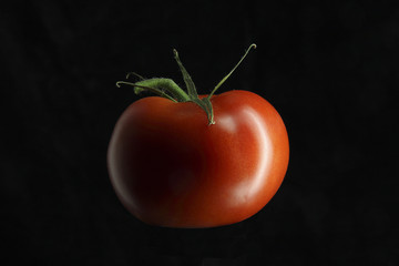 round tomato on black background