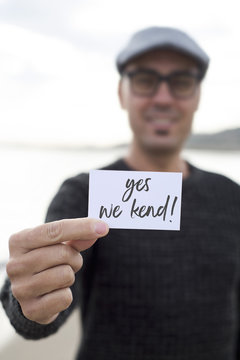 man shows signboard with the text yes we kend