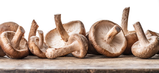 Shiitake mushrooms on the wooden background.
