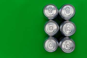 Silver metal drinks cans on green background