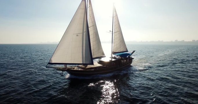 Sailing boat navigating with open sails in the sea