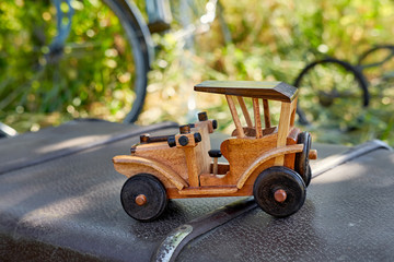 Vintage toy car. Retro Wooden toy car. A children's retro car is located on the suitcase. nostalgia and simplicity concept.