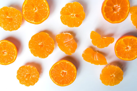 Sliced tangerine on white background flat lay
