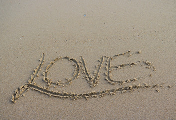 Valentine's day concept - LOVE inscription on a beach sand.valentine's written on sandy beach