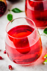 Glass of  pomegranate juice on white marble background. Selective focus, copy space, close up.
