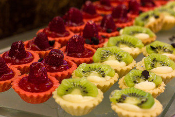 Dessert of raspberry and kiwi with cream and jelly in crisp tartlets