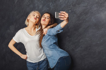 Two happy women taking selfie at studio background