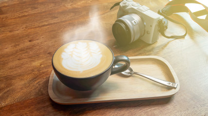 hot latte and camera on the wooden table