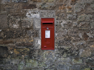 Red Royal Mail letterbox in a stone wall in Scotland