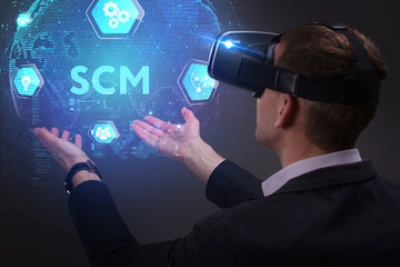 Business, Technology, Internet and network concept. Young businessman working on a virtual screen of the future and sees the inscription: SCM