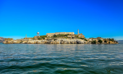Alcatraz Island and former federal penitentiary on sunny day in San Francisco Bay, California