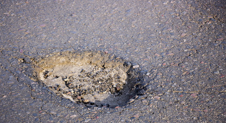 there are many potholes on the roadway close up