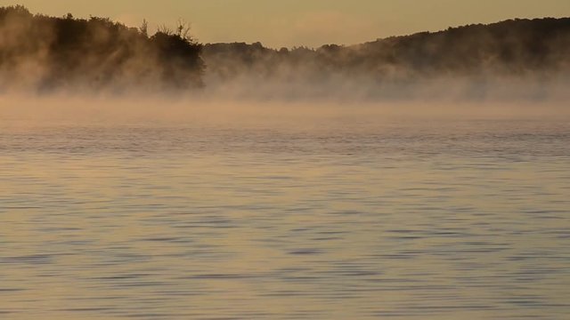 Mist moving on the lake at sunrise