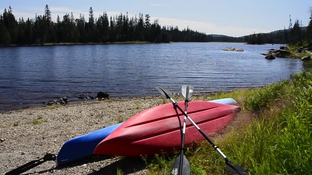 Canoe and kayak on the shore of small lake