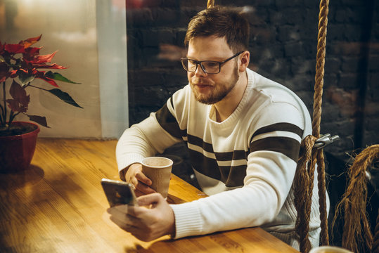 man drink tea and check his phone