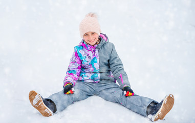 Girl having fun while sitting on the snow