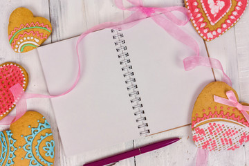 Obraz premium Gingerbread heart and a book with blank pages. wooden background. Holiday Cookies.