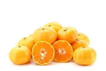 Pile of many orange fruits on white background, side view, have some have some piece sliced can see seed inside.