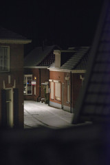 Street and houses in snow at night. Geesteren, Achterhoek, Gelderland, Netherlands.