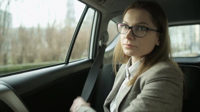Young Woman Getting Into the Car and Fastening a Seat Belt