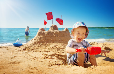 boy sitting smiling at the beach