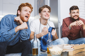 Men watching sport on tv together at home boxing