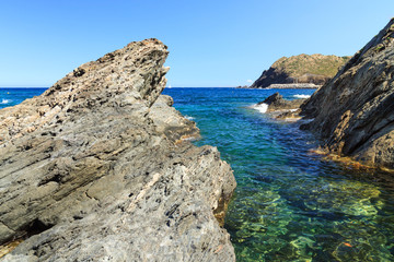 Fototapeta na wymiar Rocky coast near tourist town Portbou (Costa Brava, Catalonia, Spain)