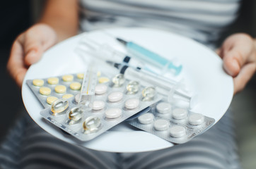 Hands holding a plate of pills