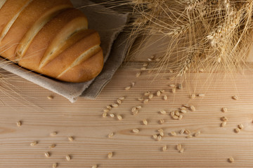 Rustic delicious aromatic fresh baguette, loaf and wheat on wooden table copyspace,text space. baking, ingredients, cooking pastry diet healthy nutrition shop store produce