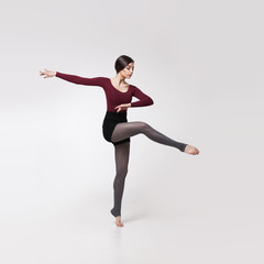 Obraz premium young woman dancer in maroon swimsuit posing