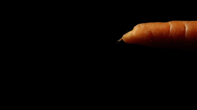 moving and rotating carrot on black background