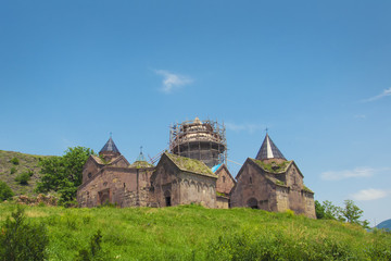 Fototapeta premium Goshavank, Nor Getik - Armenian medieval monastic complex of XII-XIII centuries in the village of Ghosh in Armenia. View of a green meadow and blue sky.