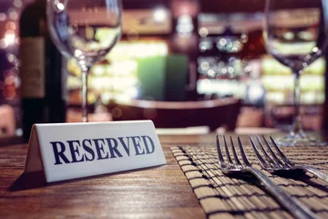 Rolgordijnen Gereserveerd teken op restaurantlijst met barachtergrond © Brian Jackson
