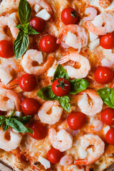 Seafood pizza with shrimps and tomatoes background. Tasty italian food concept