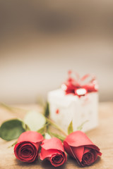 Valentines Day Background with Gift Box and Red Rose on Wood Table Rustic style