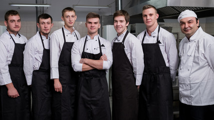Only one will become a sous chef. Male cooks standing in a restaurant kitchen before their job interview. Confident and well-trained professionals concept