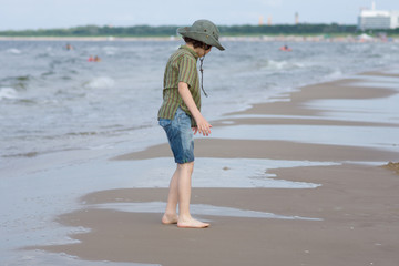 The guy is happy on the sandy beach of the sea.