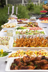 Delicious openair event fresh and yummy food, white table with various meals and snacks, bright light. 