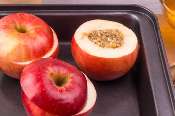 Apples in crock pot-oven, honey and nuts on a wooden background