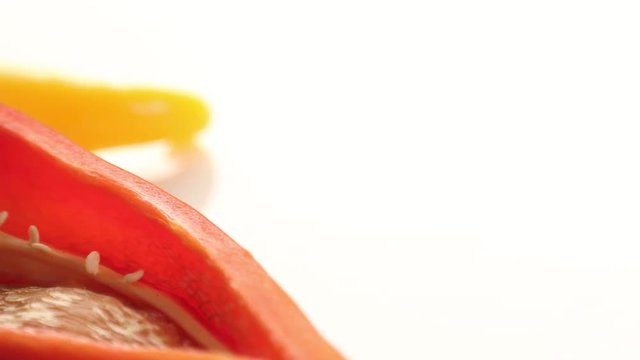 sliced red and yellow capsicum on white background