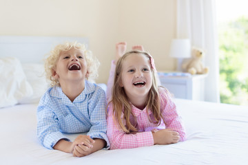 Kids in bed. Children in pajamas. Family bedroom.