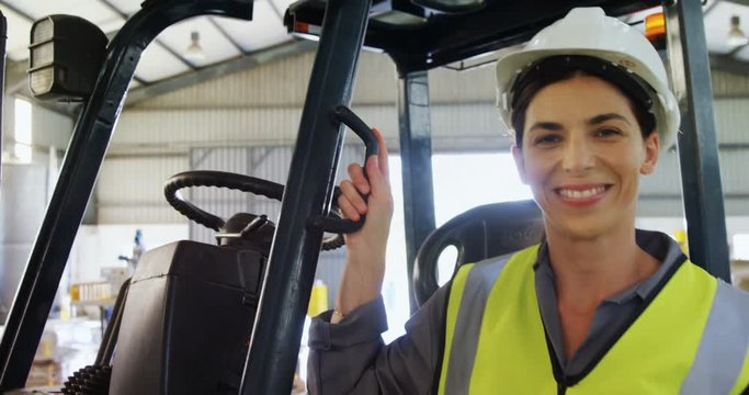 Portrait of happy worker standing near forklift 